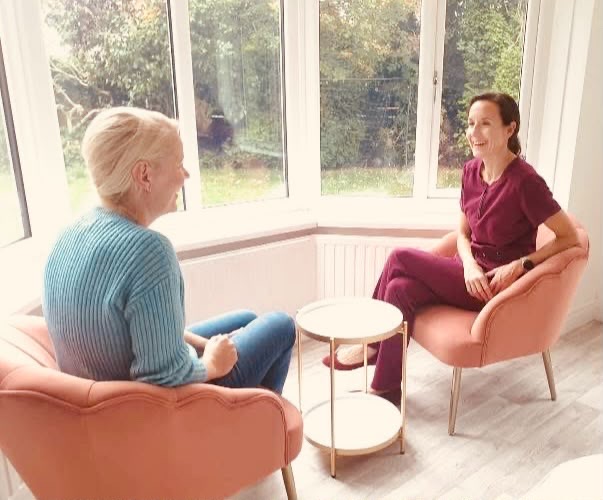 Dr. Charlotte consulting with a patient in a bright, modern clinic room